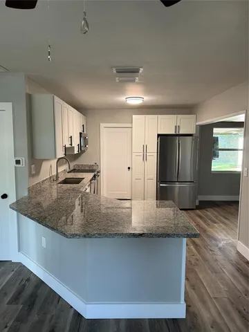 a kitchen with kitchen island granite countertop a sink a counter space and stainless steel appliances