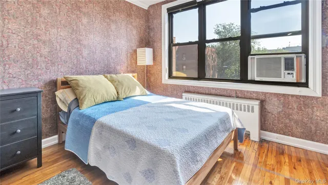 a bedroom with a bed and a large window