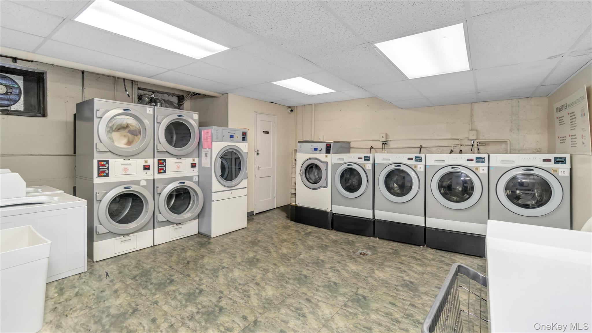 15 Canterbury Road, Unit D18 Great Neck, NY 11021 - Photo 9 of 10 Community laundry featuring tile patterned floors, separate washer and dryer, and stacked washer / dryer