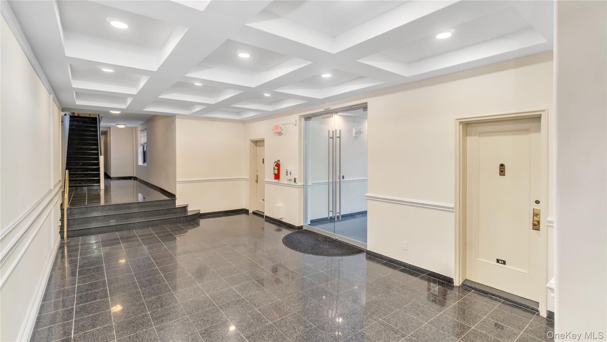15 Canterbury Road, Unit D18 Great Neck, NY 11021 - Photo 10 of 10 Lobby with coffered ceiling, beam ceiling, recessed lighting, and stairway