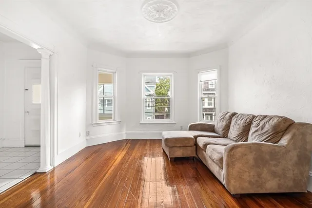 a living room with furniture and a hard wood floor