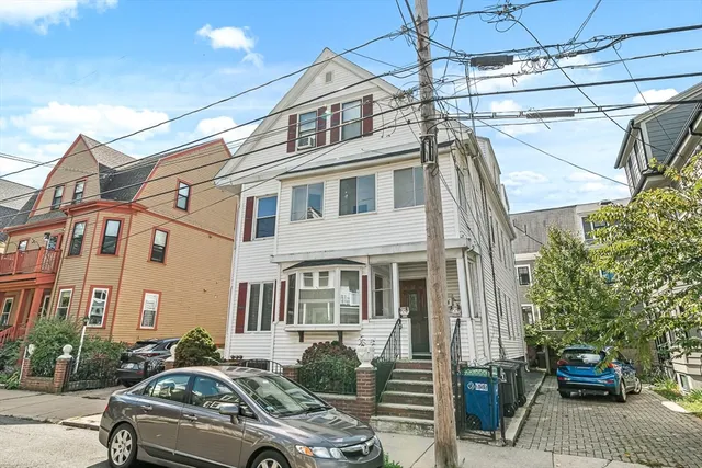 a couple of cars parked in front of a building
