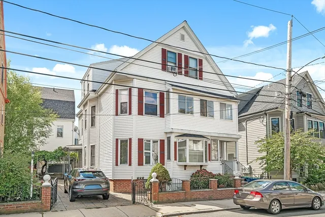 a car parked in front of a white house