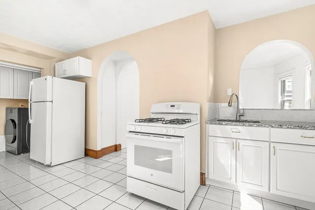 a kitchen with white cabinets and white appliances
