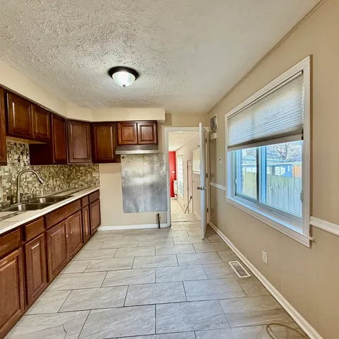 a large kitchen with stainless steel appliances granite countertop a stove and a sink