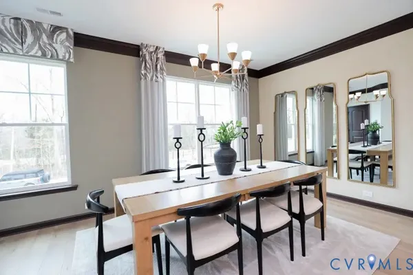 a dining room with wooden floor a chandelier a wooden table and chairs