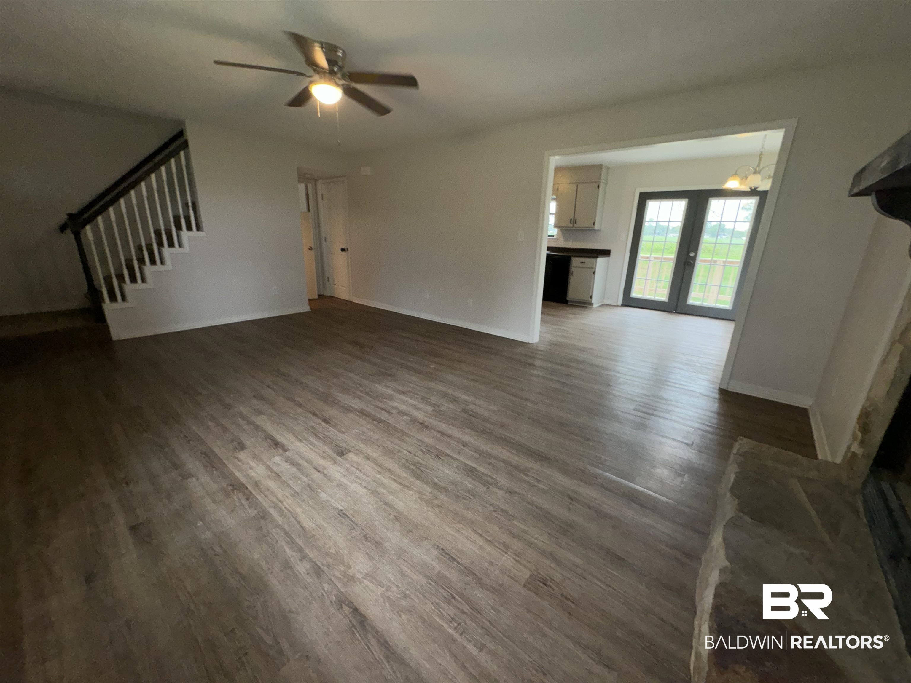 70 Plum Street Uriah, AL 36480 - Photo 5 of 36 Unfurnished living room with ceiling fan, french doors, and dark wood-type flooring