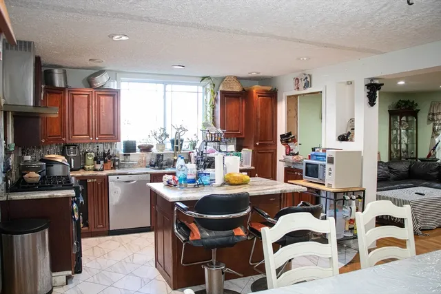a kitchen with a table chairs microwave and cabinets