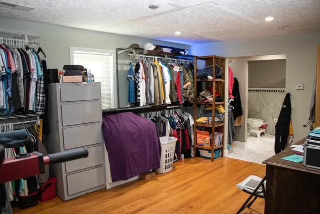 a view of walk in closet with clothes and shoes