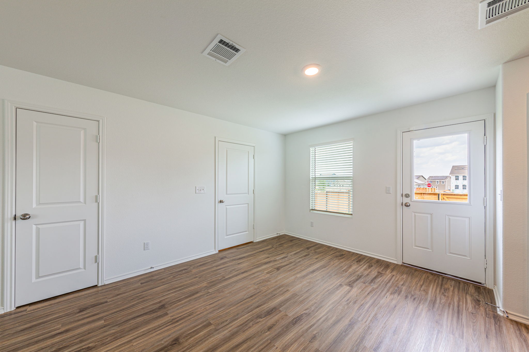 252 Patagonia Kyle, TX 78640 - Photo 8 of 30 an empty room with wooden floor and windows