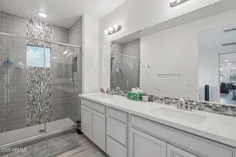 a bathroom with a double vanity sink mirror and shower