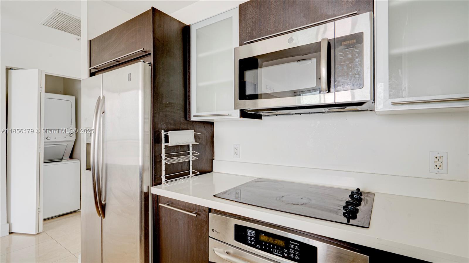 90 Southwest 3rd Street, Unit PH10 Miami, FL 33130 - Photo 9 of 23 a kitchen with stainless steel appliances a refrigerator and a microwave