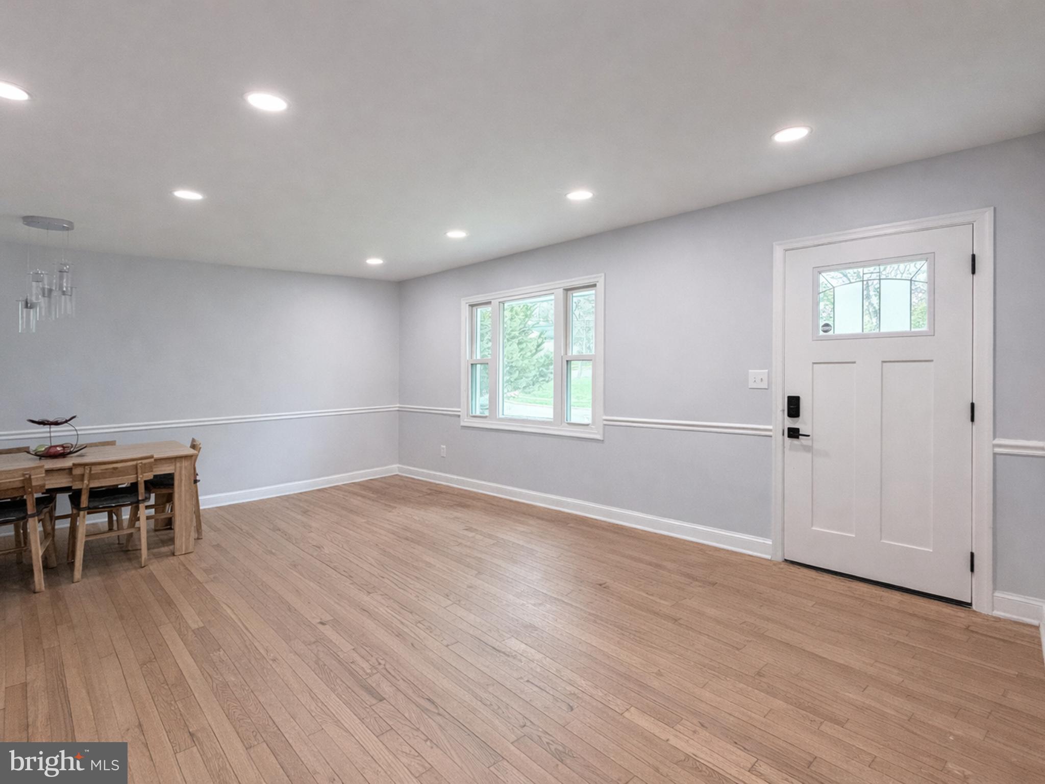 4902 91st Place Lanham, MD 20706 - Photo 11 of 30 an empty room with wooden floor and windows