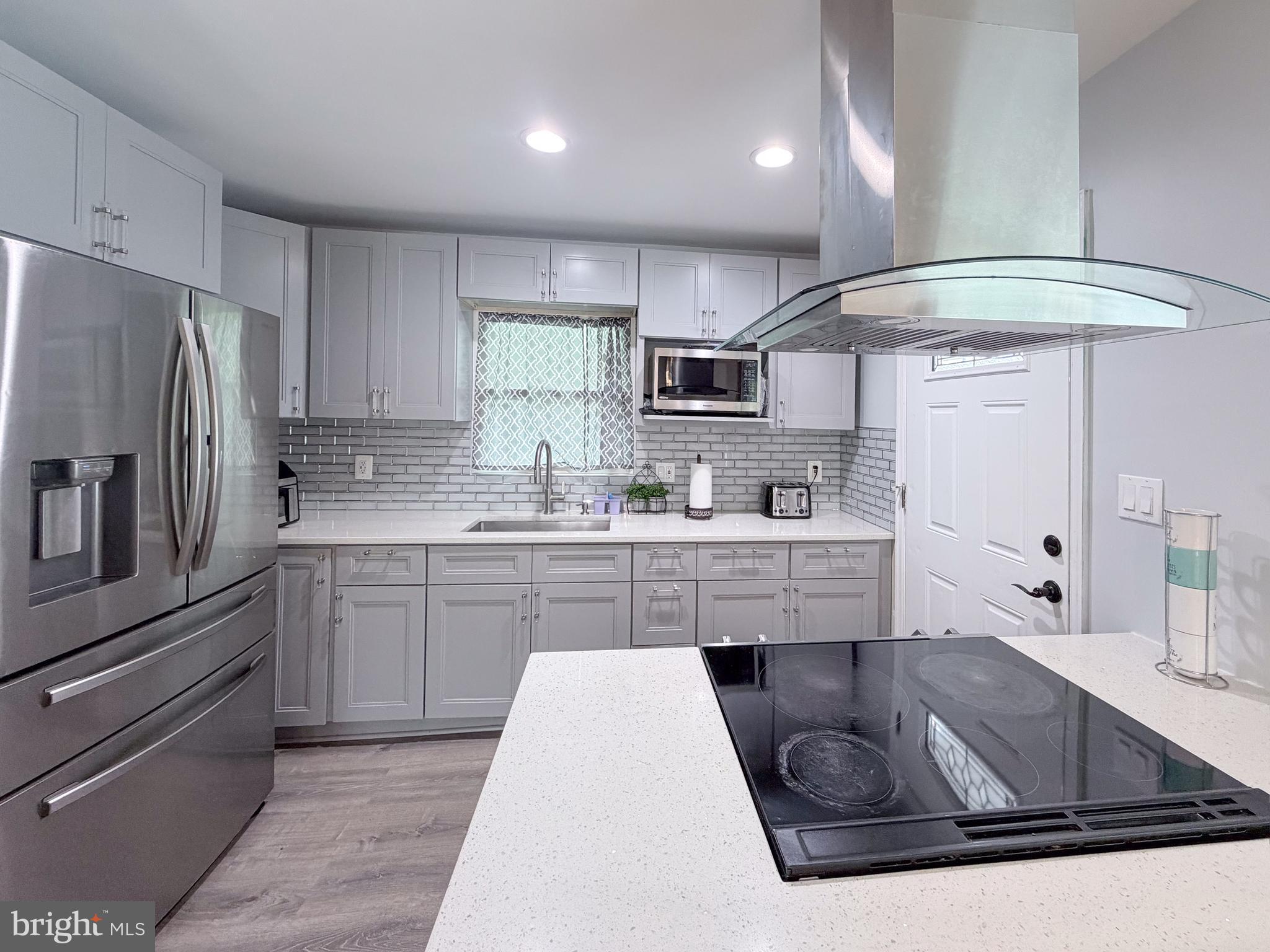 4902 91st Place Lanham, MD 20706 - Photo 12 of 30 a kitchen with stainless steel appliances granite countertop a sink stove and refrigerator
