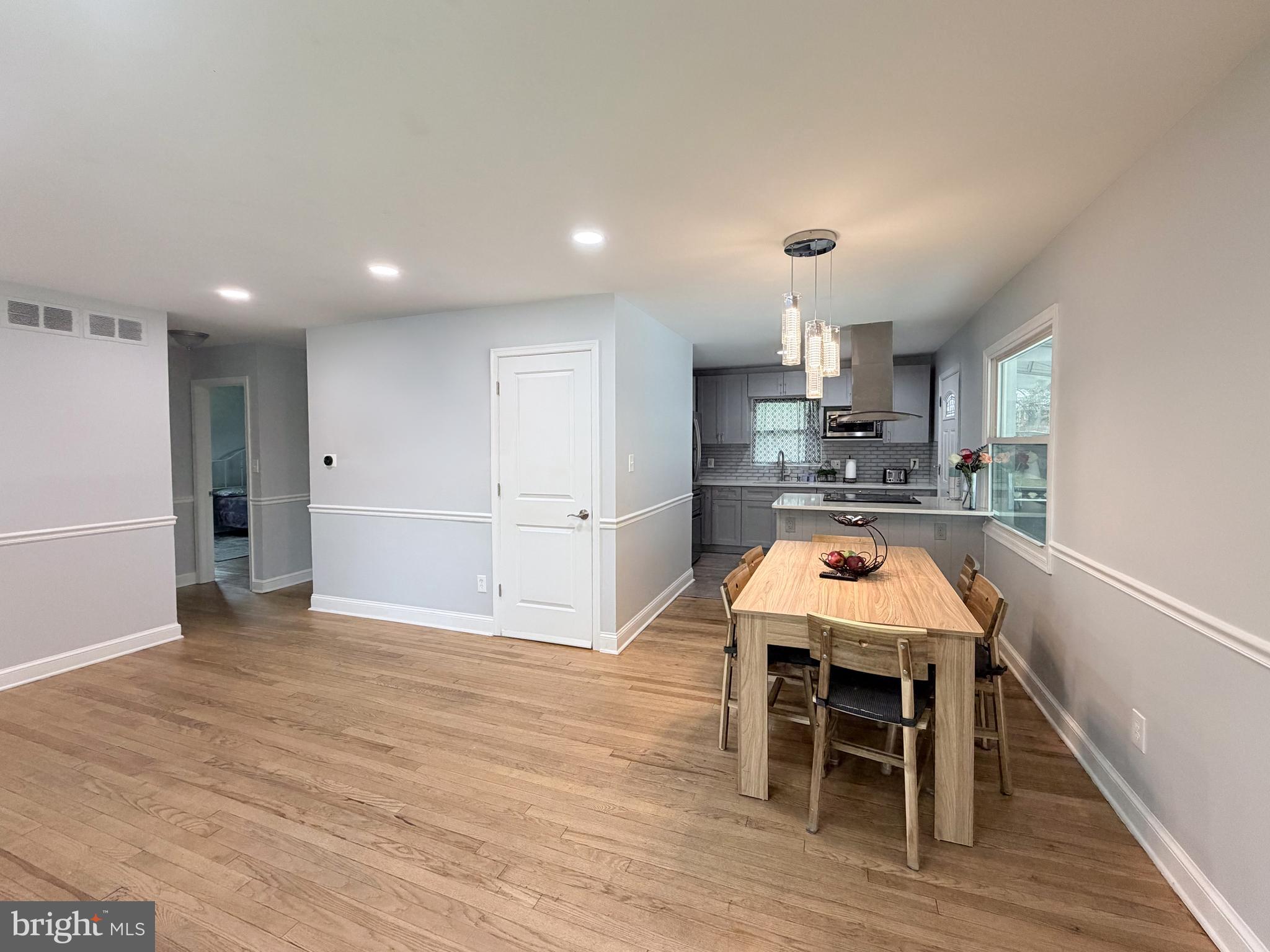 4902 91st Place Lanham, MD 20706 - Photo 14 of 30 a kitchen with stainless steel appliances a dining table chairs and wooden floor