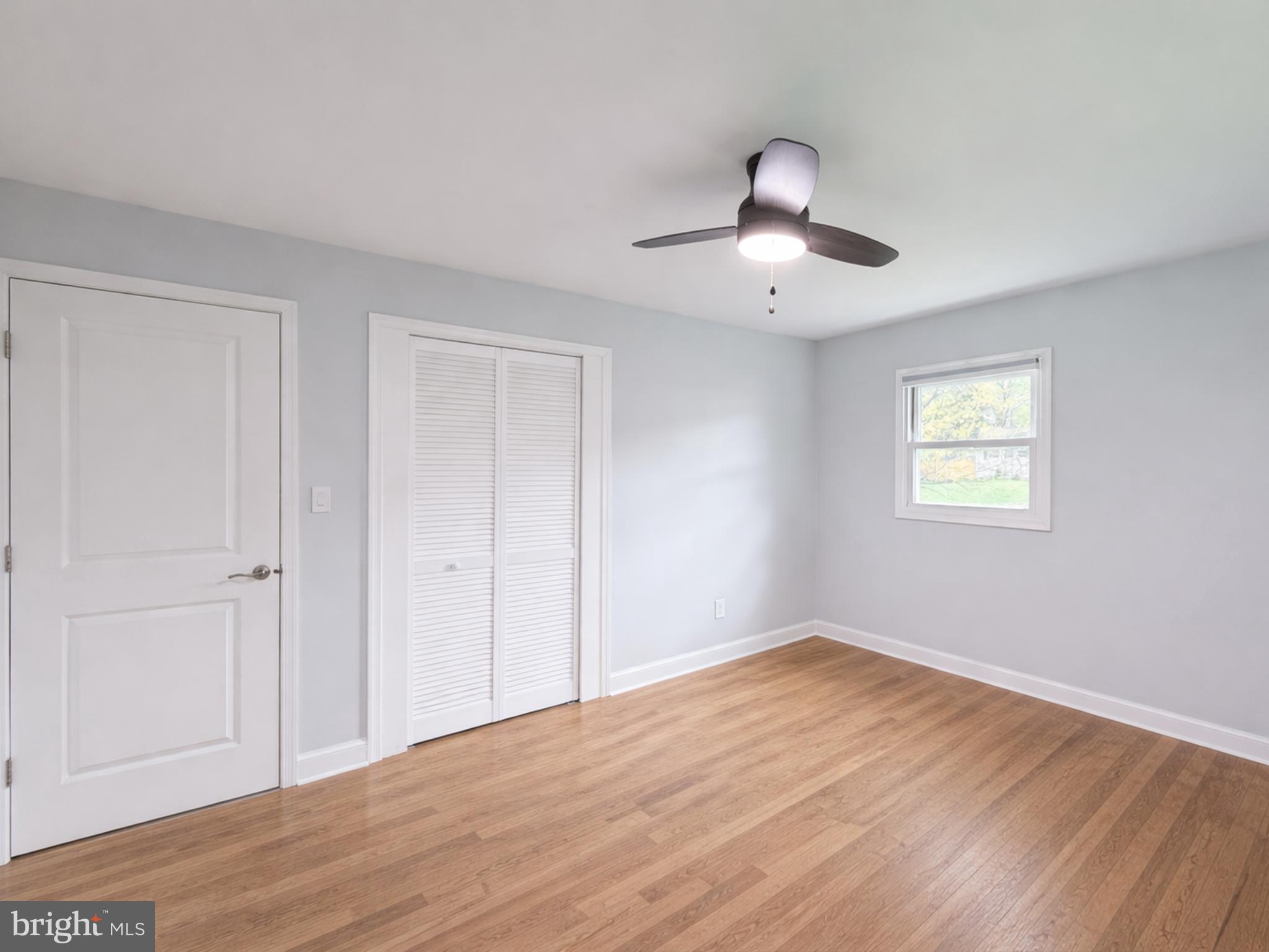 4902 91st Place Lanham, MD 20706 - Photo 18 of 30 a view of an empty room with wooden floor and a window