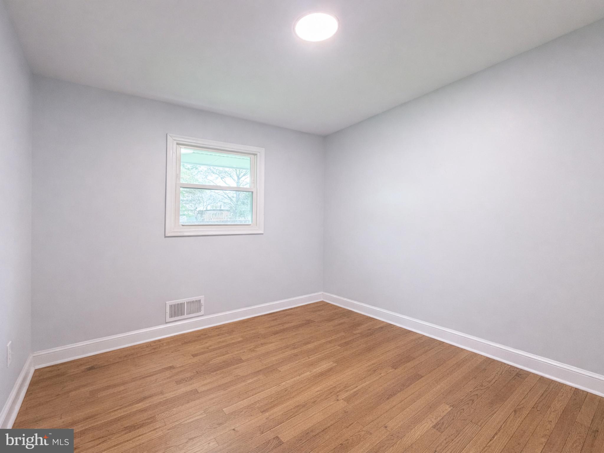 4902 91st Place Lanham, MD 20706 - Photo 20 of 30 an empty room with wooden floor and windows