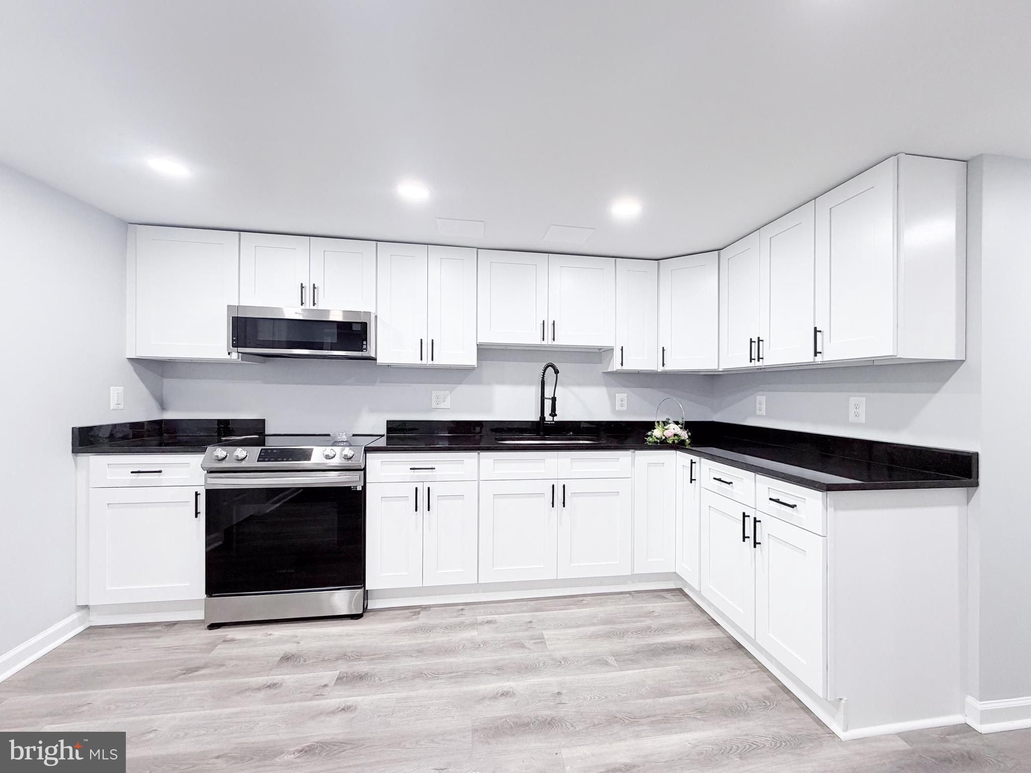 4902 91st Place Lanham, MD 20706 - Photo 26 of 30 a kitchen with stainless steel appliances granite countertop a stove a sink and a microwave