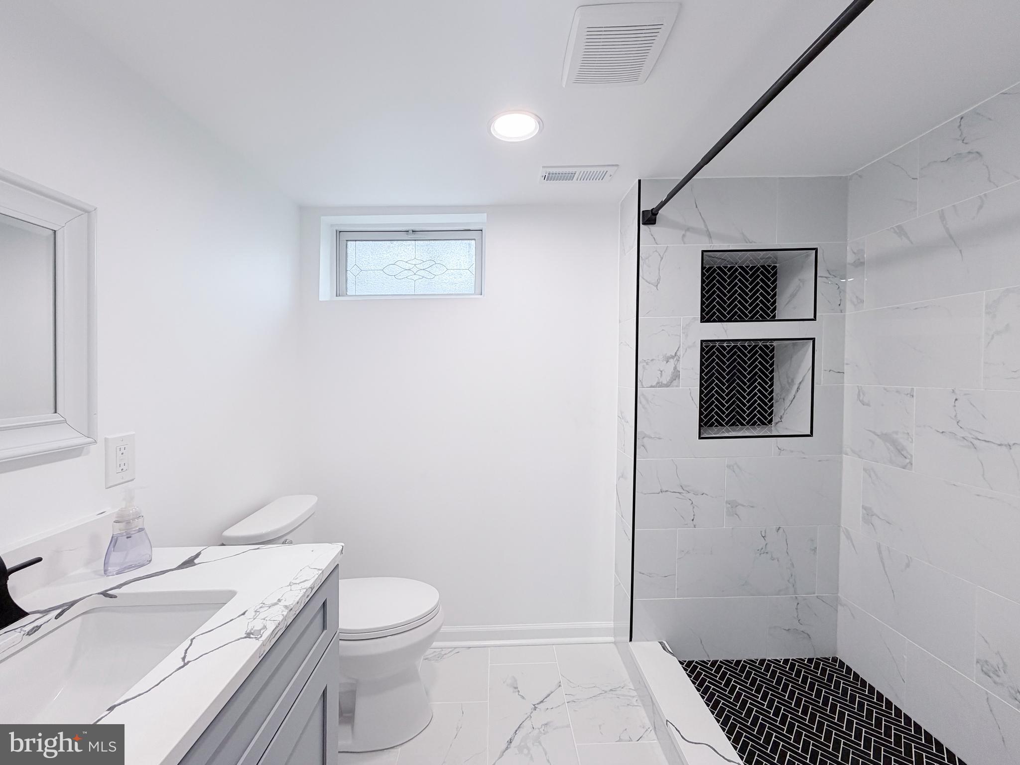 4902 91st Place Lanham, MD 20706 - Photo 28 of 30 a bathroom with a granite countertop toilet and a sink