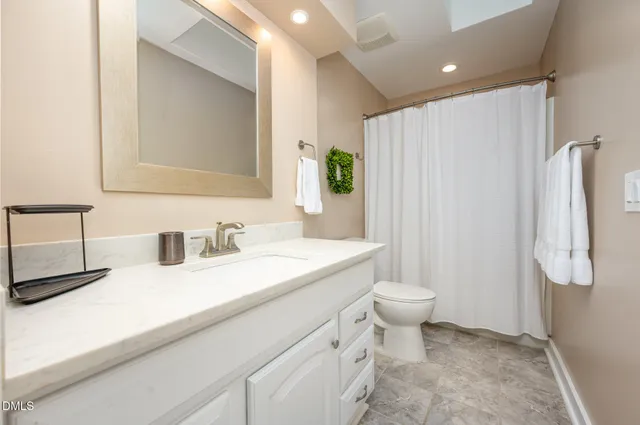 a bathroom with a sink a toilet and shower curtain