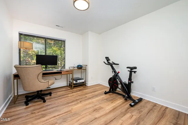 a view of a workspace with furniture and a window