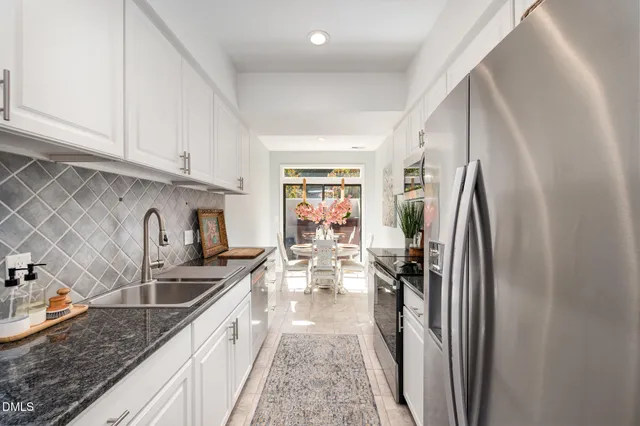 a kitchen with granite countertop a sink stove and refrigerator