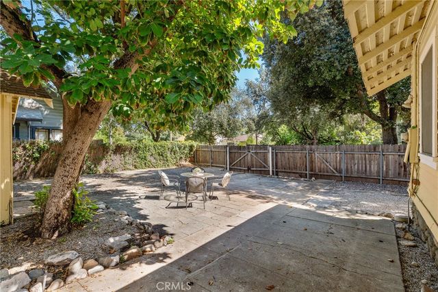 a view of backyard with table and chairs and wooden fence