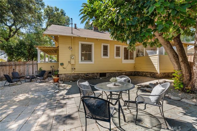 a view of a patio with table and chairs and wooden fence