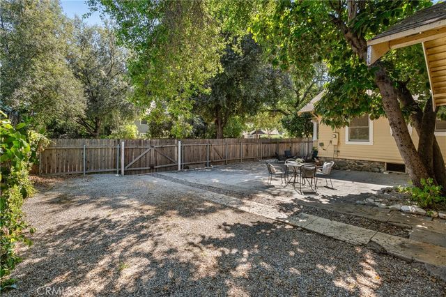 a view of a backyard with a tree and wooden fence