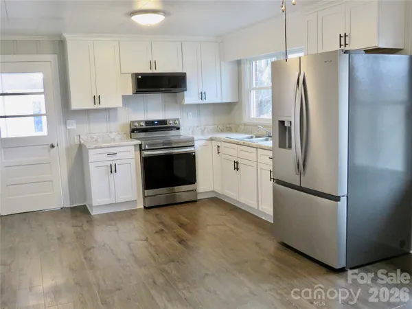 a kitchen with stainless steel appliances granite countertop a refrigerator stove and a sink