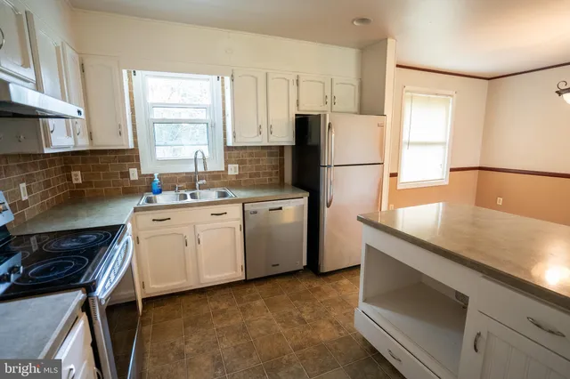 a kitchen with a sink appliances and cabinets
