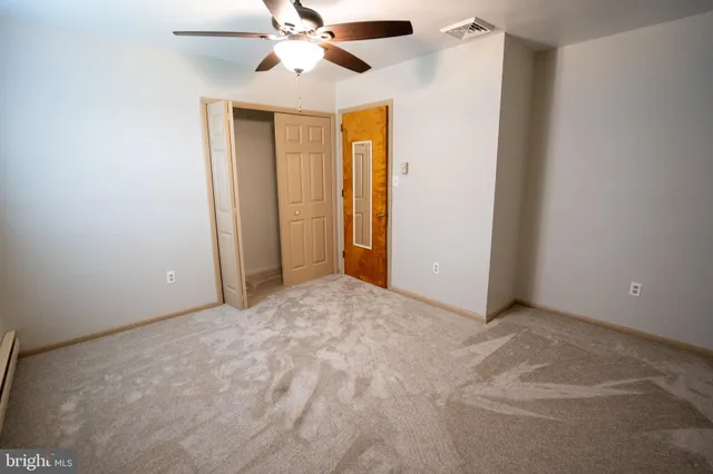 an empty room with a ceiling fan and a window