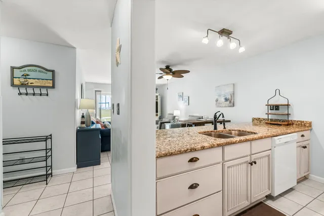 a kitchen with granite countertop white cabinets and white appliances