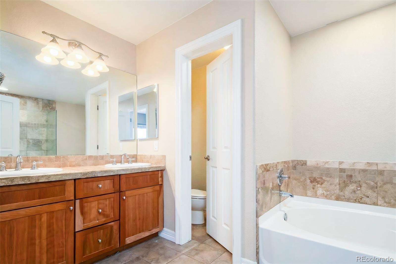 2245 South High Street Denver, CO 80210 - Photo 12 of 33 a bathroom with a granite countertop sink mirror and bathtub