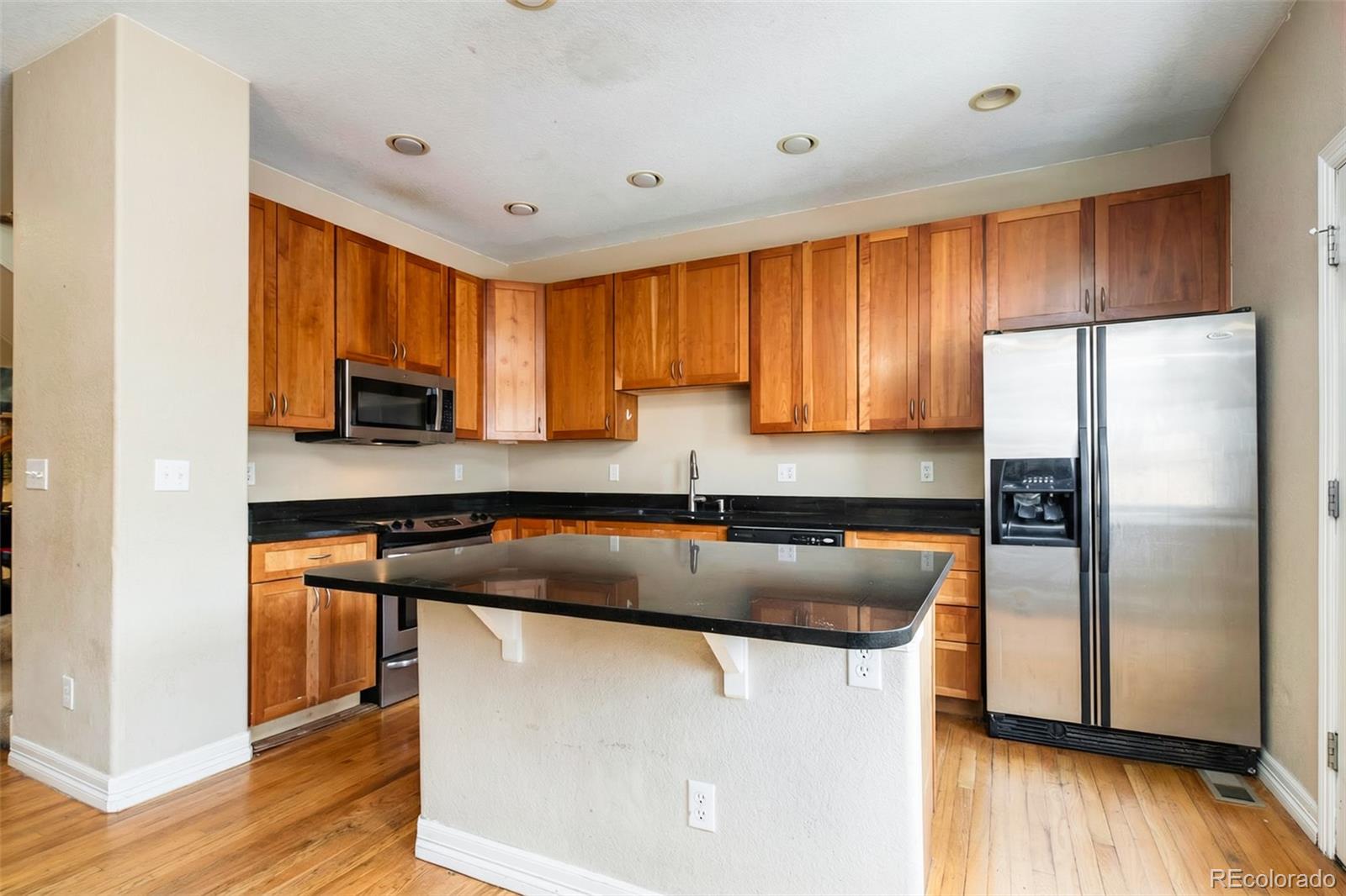 2245 South High Street Denver, CO 80210 - Photo 2 of 33 a kitchen with stainless steel appliances granite countertop a refrigerator a sink a stove a microwave and island with wooden floor
