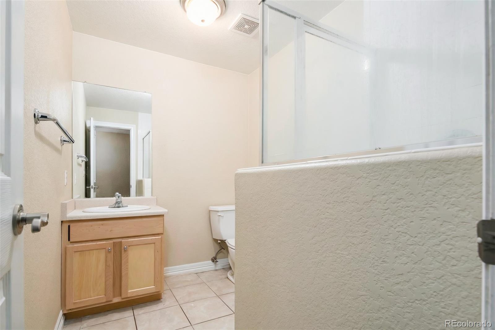2245 South High Street Denver, CO 80210 - Photo 25 of 33 a bathroom with a sink a toilet and mirror