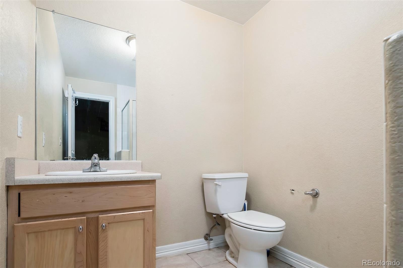 2245 South High Street Denver, CO 80210 - Photo 26 of 33 a bathroom with a toilet sink and mirror