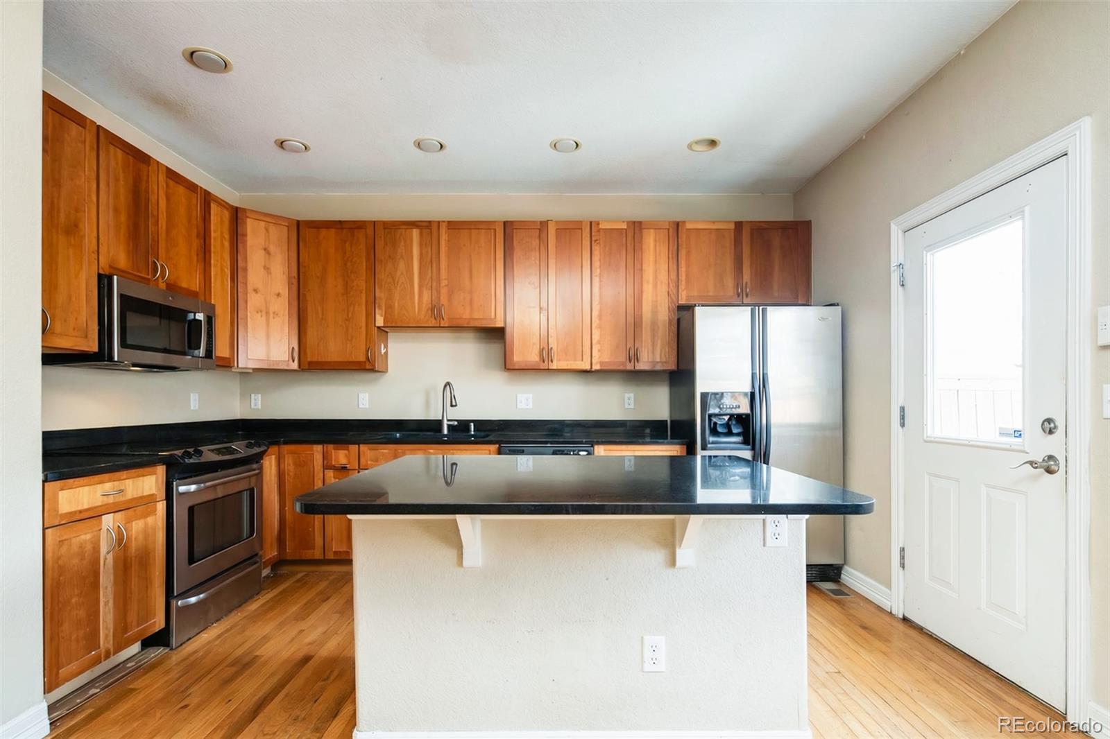 2245 South High Street Denver, CO 80210 - Photo 6 of 33 a kitchen with granite countertop cabinets stainless steel appliances a sink and a window