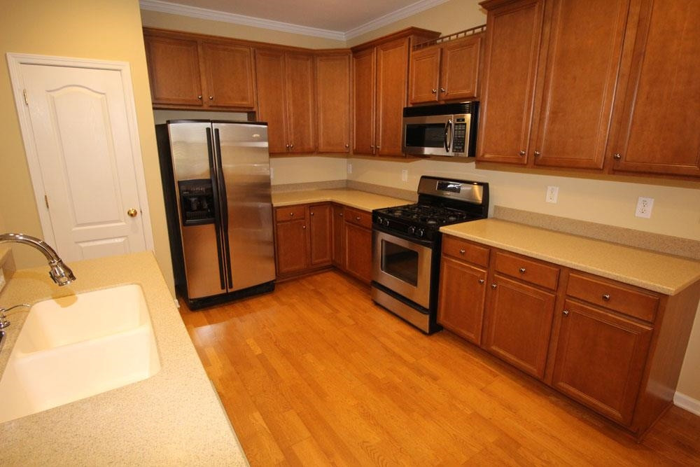 6952 Middleboro Drive Raleigh, NC 27612 - Photo 6 of 32 Kitchen features gas stove, 42” cabinets, solid surface counters & stainless steel appliances. Ktichen