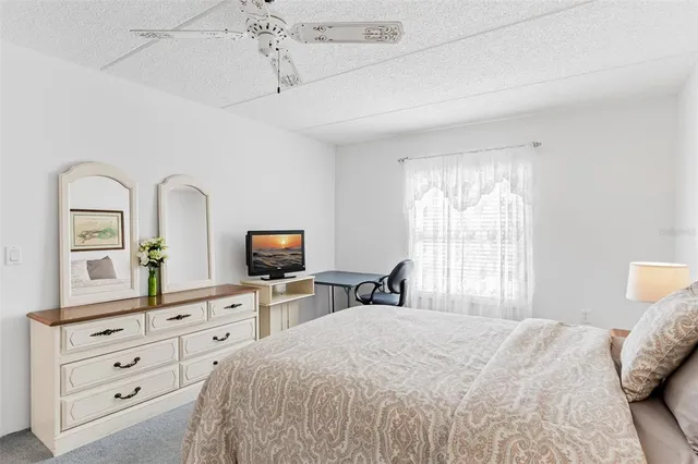 a bedroom with a bed a window and dresser