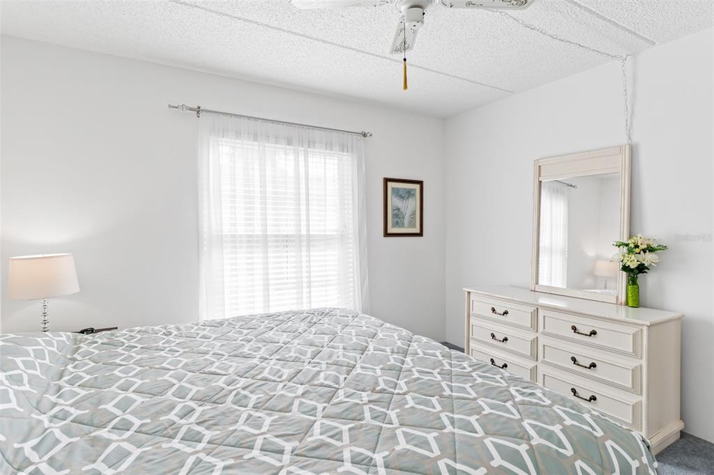 12760 Indian Rocks Road, Unit 546 Largo, FL 33774 - Photo 19 of 45 a bedroom with a bed a dresser and a chandelier