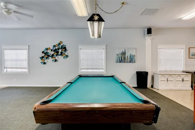 a room with pool table and windows