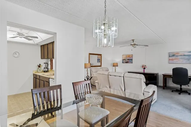 a view of a dining room with furniture a chandelier and wooden floor