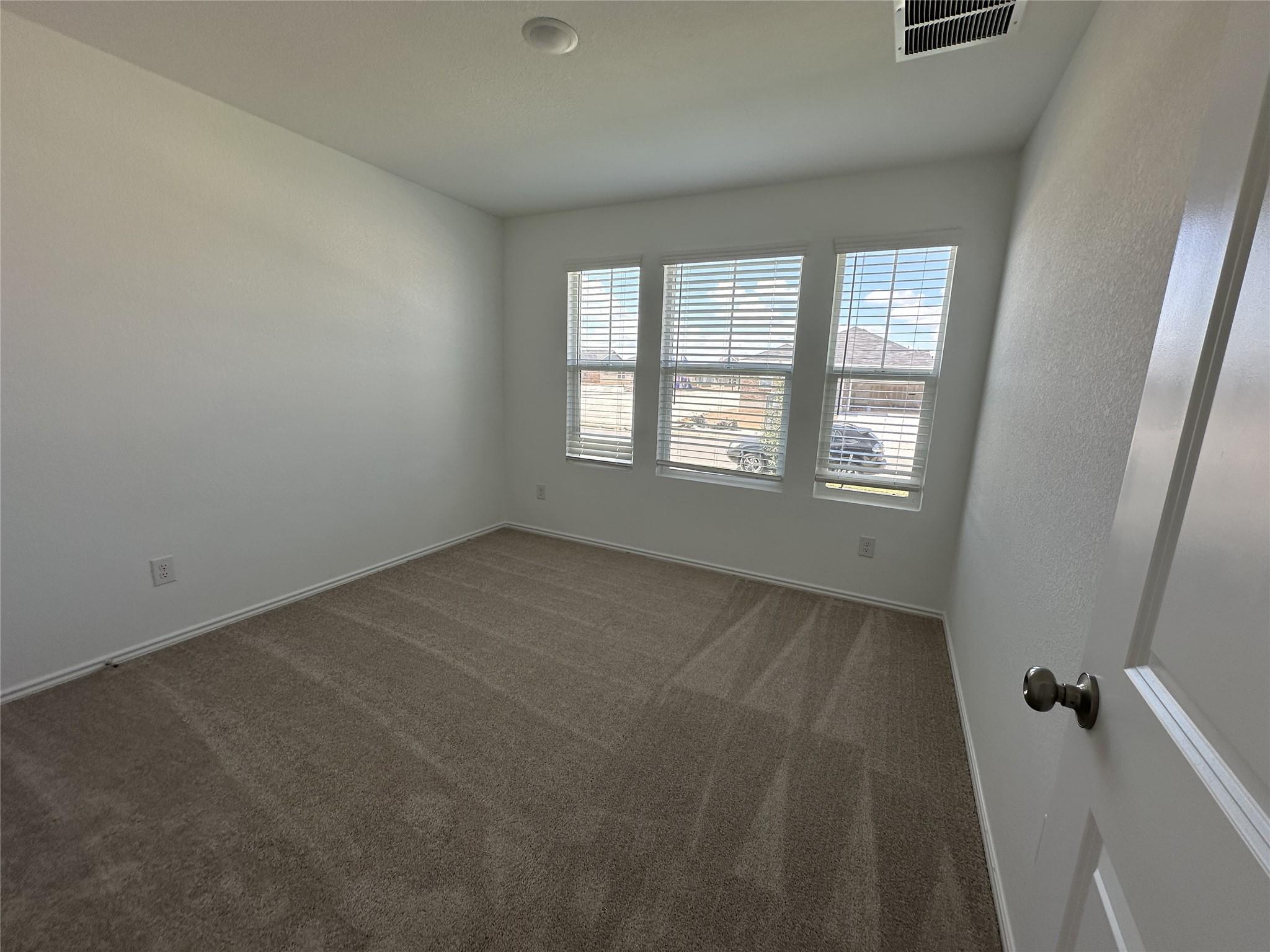 233 Magalia Lane Kyle, TX 78640 - Photo 14 of 37 Empty room featuring carpet and baseboards