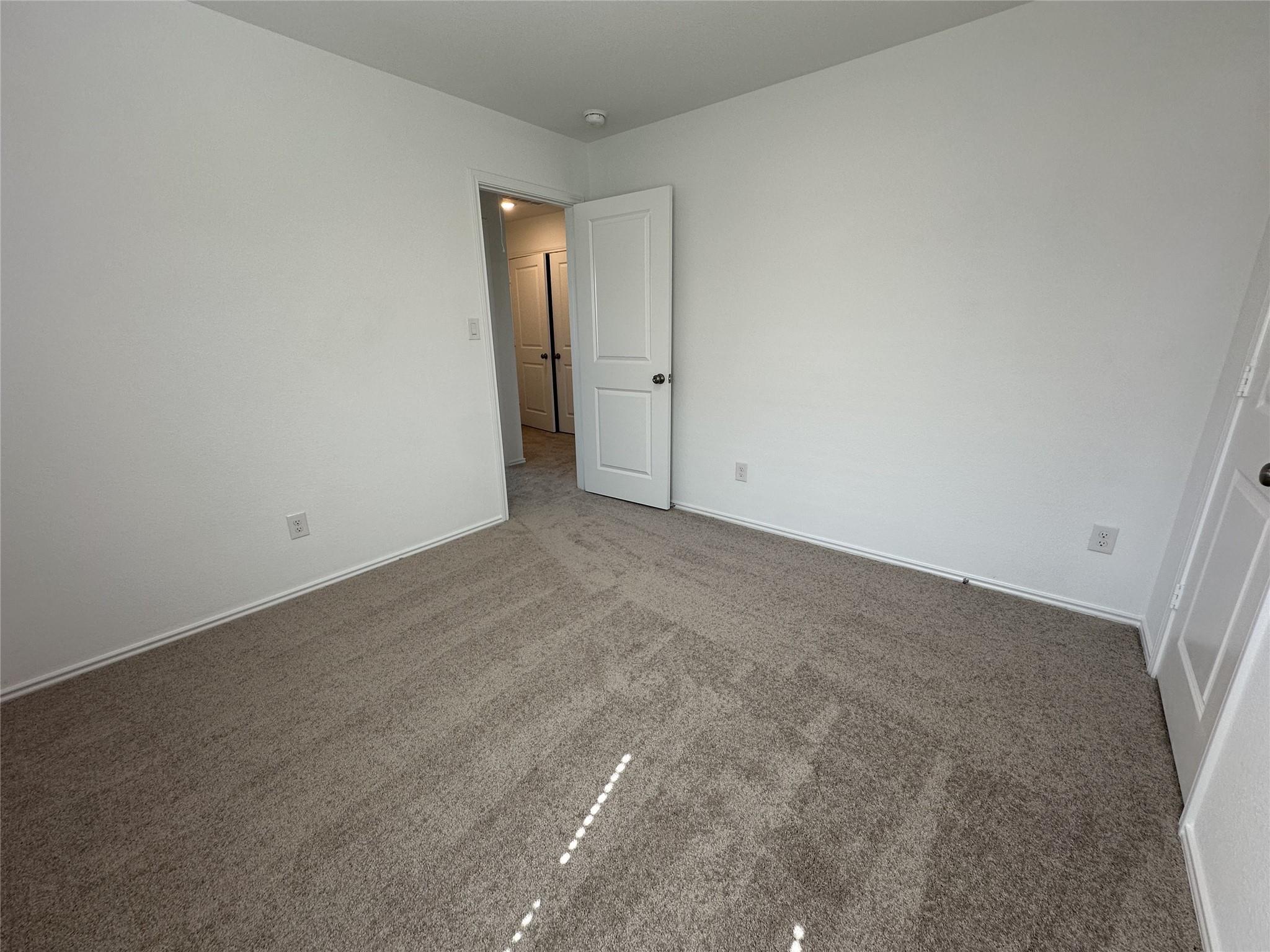 233 Magalia Lane Kyle, TX 78640 - Photo 18 of 37 Unfurnished bedroom with carpet floors and baseboards