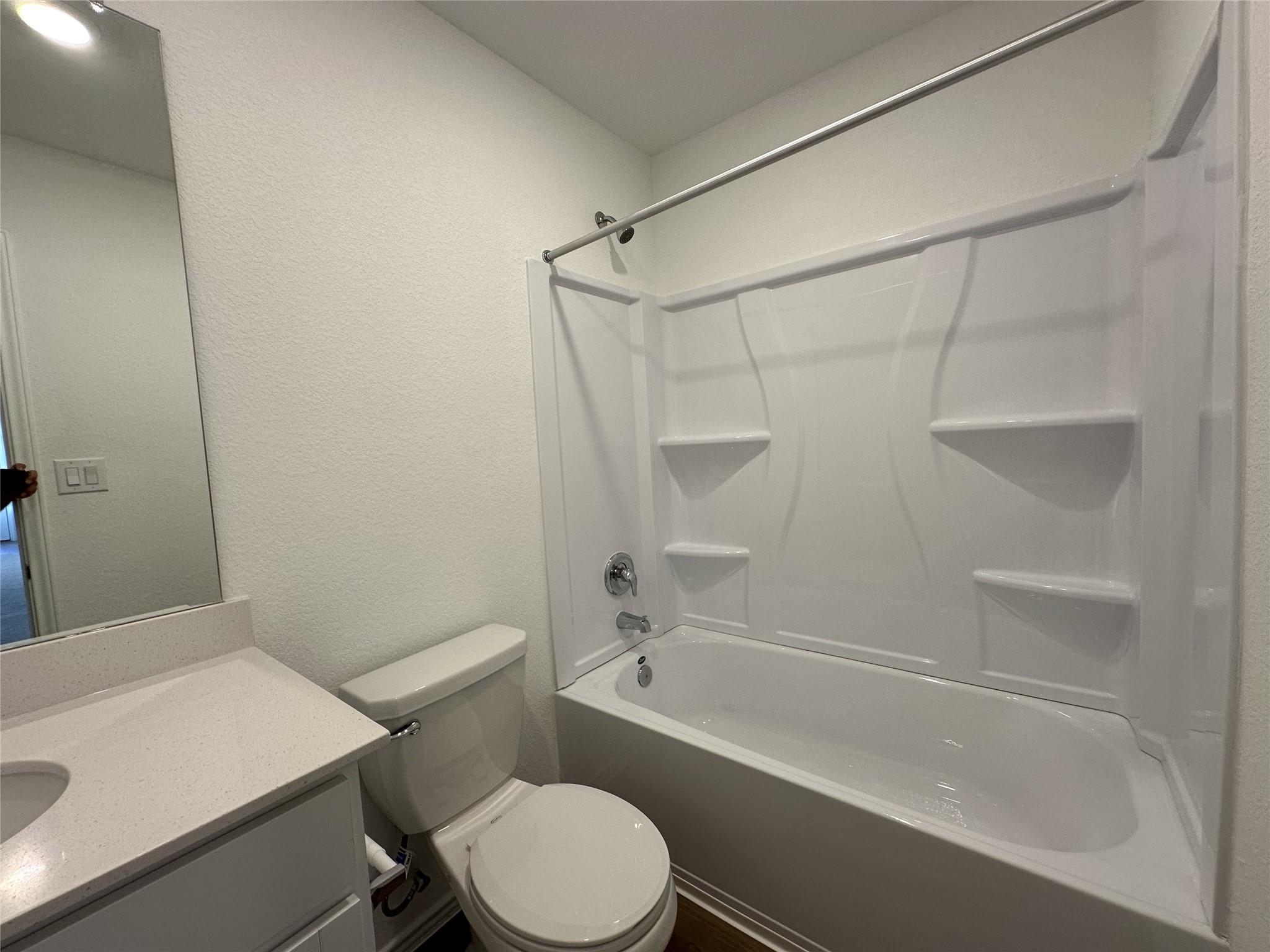 233 Magalia Lane Kyle, TX 78640 - Photo 21 of 37 Full bathroom with a textured wall, bathing tub / shower combination, and vanity