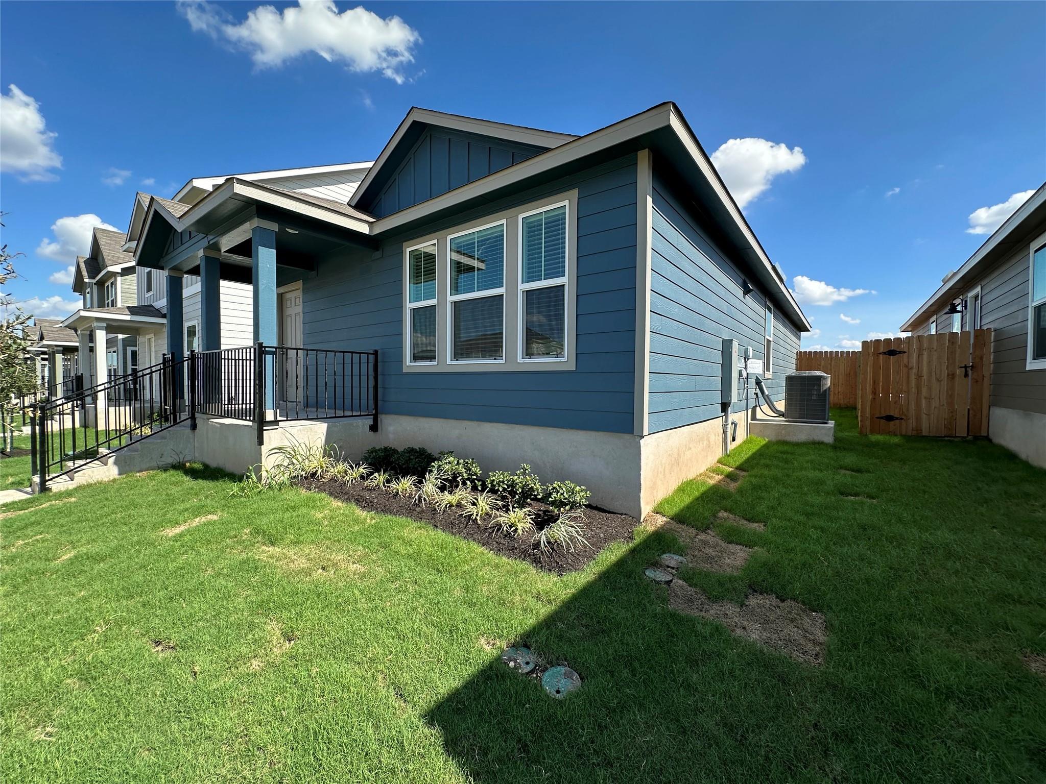 233 Magalia Lane Kyle, TX 78640 - Photo 31 of 37 View of side of property with board and batten siding and a gate