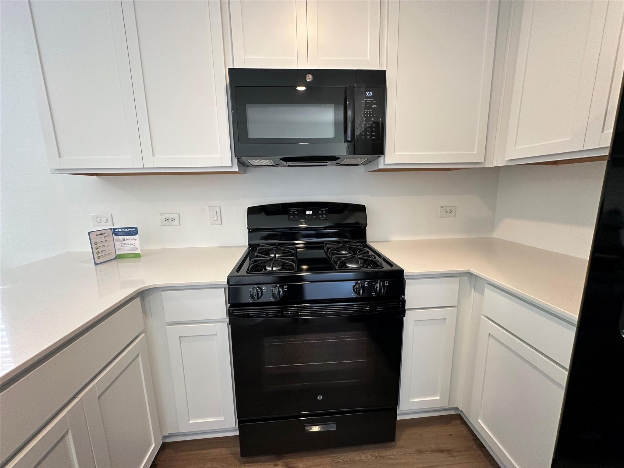 233 Magalia Lane Kyle, TX 78640 - Photo 6 of 37 Kitchen with black appliances and white cabinets