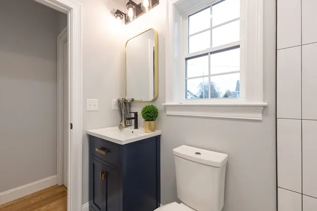 a bathroom with a sink a toilet and a window