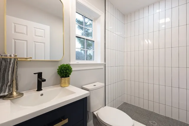 a bathroom with a sink a toilet and shower